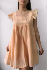 Vestido corto color melón, con escote cuadrado, mangas cortas con volados y corte evasé.