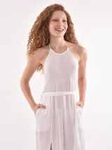 Mono largo blanco con textura plisada, escote halter y aberturas laterales en la pierna. Incluye un lazo fino a juego para ajustar a la cintura.