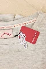 Pijama de algodón gris melange con estampado de gatos, compuesto por una remera de manga corta con cuello redondo y un pantalón largo de corte recto con cintura elástica.