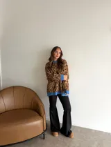 Pantalón tipo oxford de tiro alto, color negro, con corte ajustado en la parte superior y acampanado desde la rodilla hacia abajo.