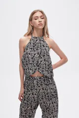 Top cropped de viscosa con estampado paisley en tonos negro y beige, diseño sin mangas con cuello halter y detalle de lazada.
