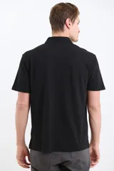 Remera verde con cuello polo y tapeta de dos botones. Corte clásico y mangas cortas.