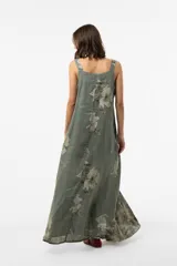 Vestido largo verde militar con estampado floral, silueta amplia, escote redondo y tirantes finos con detalle de botones.