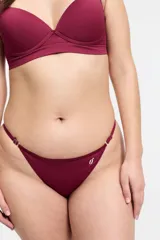 Bombacha tipo colaless color bordó, con cintura regulable mediante herrajes metálicos y detalle de logo bordado en el frente. Confeccionada en microfibra sin costuras.
