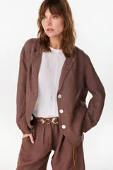 Blazer de lino italiano color marrón, de botonadura sencilla con tres botones claros, solapas clásicas, bolsillos de parche y detalle de puño tableado.