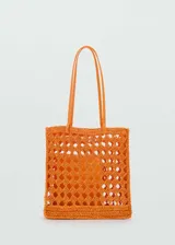 Bolso tipo shopper de diseño calado, confeccionado en tejido de fibra natural color naranja. Cuenta con doble asa larga para llevar al hombro y un bolsillo interior.