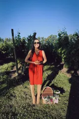 Vestido corto sin mangas de color rojo, con escote en V y detalle de alforzas verticales en el frente. Presenta un diseño de silueta relajada y fluida.