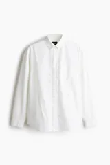 Camisa Oxford de algodón blanca, de corte regular fit, con cuello americano, bolsillo frontal aplicado y mangas largas con puños abotonados.