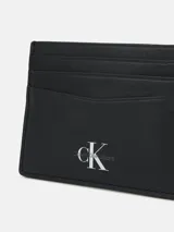 Tarjetero negro de cuero con seis ranuras para tarjetas y logo de Calvin Klein Jeans grabado en la parte delantera.