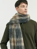 Bufanda de estilo escocés con textura peluda, diseño a cuadros en tonos gris, beige y azul, con flecos en los extremos.