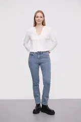 Pantalon jean de corte skinny y tiro alto, con diseño clásico de cinco bolsillos y cierre frontal con botón y cremallera.