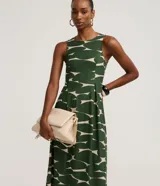 Vestido midi sin mangas de la marca Cortelle, confeccionado en piqué con estampa abstracta bicolor en verde y beige, con cuello redondo y cierre posterior por gota.