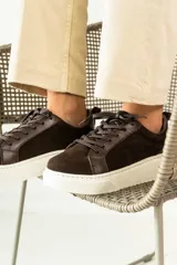 Zapatillas urbanas de cuero, color marrón oscuro, con paneles de gamuza y cuero liso, cordones al tono y suela de plataforma blanca.