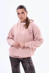 Buzo tipo canguro oversize de felpa color beige, con capucha y estampa gráfica circular en la espalda con texto y una estrella.