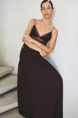 Vestido largo de tirantes finos con escote en pico, cuerpo con frunces elásticos y detalle de encaje a tono en la parte superior. Cuenta con forro interior y falda fluida.