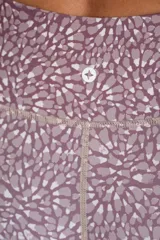 Legging deportivo de tiro alto con estampado botánico abstracto en tonos rosados y marrones, confeccionado en tejido elástico de secado rápido.