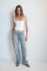 Jeans de mezclilla de tiro medio con cinco bolsillos, diseño relaxed fit de corte recto y amplio, con efecto lavado y desgaste frontal.
