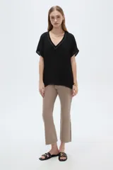 Blusa de poliéster negra, de corte holgado, manga corta y escote en V con detalle de strass.
