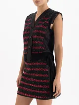 Minifalda negra con bordado frontal de lentejuelas en forma de cerezas, detalle de cinto tejido en lana y volado de organza plisada en el ruedo.