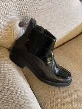 Botas cortas negras de cuero vacuno con elástico lateral y cierre.