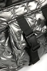 Cartera tipo tote bag color verde oscuro brillante, con diseño acolchado y correas negras. Presenta dos correas frontales con hebillas de plástico negras y un bolsillo frontal.