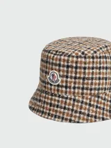 Sombrero tipo bucket reversible con estampado a cuadros en tonos marrón, beige y negro.