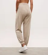 Pantalón deportivo tipo jogger confeccionado en plush color verde oliva, con cintura elástica, bolsillos laterales y puños ajustados en los tobillos.