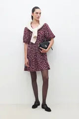 Vestido midi de color bordó con estampado floral blanco, mangas cortas abullonadas y falda con volantes.