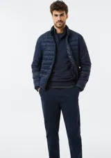 Campera puffer azul marino, con diseño acolchado de líneas horizontales, cuello alto y cierre frontal completo.