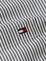 Camisa de popelina a rayas verticales blancas y negras, con cuello clásico, cierre con botones, bolsillo de parche en el pecho y logo de Tommy Hilfiger bordado.