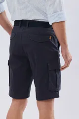 Bermuda cargo color azul marino, de gabardina con bolsillos laterales con solapa en las piernas y presillas para cinturón. Incluye cinturón de lona trenzada oscura con detalles en cuero sintético y hebilla metálica.