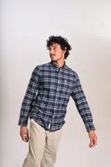 Camisa de manga larga confeccionada en tejido de franela con estampado de cuadros en tonos azul marino y verde. Presenta cuello abotonado, cierre frontal con botones y un bolsillo en el pecho con el logo bordado de la marca.