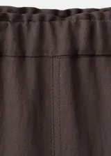 Pantalón marrón de corte recto y tiro medio, confeccionado en mezcla de lyocell y viscosa. Cuenta con bolsillos laterales y bolsillos traseros con solapa.