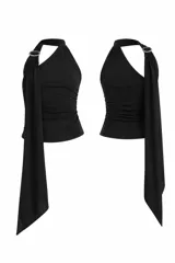 Top negro de corte asimétrico con cuello halter, drapeado lateral y una larga tira de tela que cae desde el hombro. Incluye hebilla ovalada metálica en el tirante y frunces laterales.