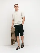 Bermuda chino de corte recto, color verde militar, confeccionada en algodón con elastano. Cuenta con bolsillos laterales de estilo italiano y bolsillos traseros con botón.