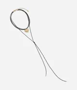 Collar en capas con cordones finos negros, un colgante de corazón texturizado en metal color oro envejecido y un cierre ajustable.