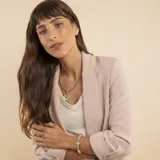 Pulsera de diseño articulado que combina eslabones de plata trenzada con detalles en oro y piezas circulares de nácar engarzadas.