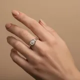 Anillo de plata 925 con una piedra de nácar ovalada en el centro.