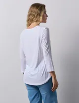 Remera blanca de modal con cuello cuadrado y aplique de aros metálicos.
