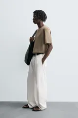 Camiseta de punto ligero color marrón topo, con cuello redondo y manga corta ancha. Presenta una textura acanalada o de estructura fina.