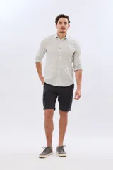 Bermuda cargo color azul marino, de gabardina con bolsillos laterales con solapa en las piernas y presillas para cinturón. Incluye cinturón de lona trenzada oscura con detalles en cuero sintético y hebilla metálica.