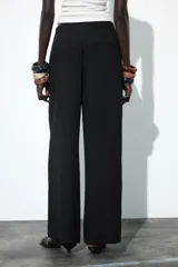 Pantalón de tiro medio color marrón, con pierna recta y detalle de superposición frontal tipo pareo.