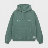 Canguro con capucha de color verde con efecto lavado, diseño de corte holgado, bolsillo frontal tipo canguro, cordones ajustables y logo estampado en el pecho.