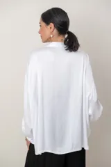Camisa de satén tramada color blanco, con calce holgado y cómodo, cuello camisero, mangas largas y cierre frontal con botones.