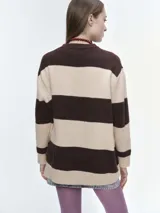 Buzo tejido de corte oversize con diseño de rayas horizontales en tonos azul y celeste. Presenta cuello redondo, hombros caídos y terminaciones acanaladas en puños y bajo.