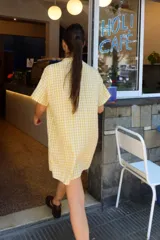 Vestido corto amarillo a cuadros blancos, con cuello mao, botones a tono, logo bordado a contratono en el frente y corte oversized.