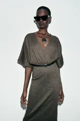 Vestido midi de escote en pico cruzado y manga corta. Presenta detalle de frunces en la cintura y un cinturón integrado con hebilla metálica a contraste.