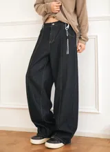 Jeans baggy de denim color azul oscuro, de corte ancho y relajado, con cintura semi-elástica en la parte trasera. Presenta bolsillos traseros con costuras a contratono y bordado de estrella en uno de ellos.