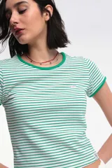 Remera baby blanca de algodón, de corte cropped al cuerpo y mangas cortas. Presenta ribetes negros en contraste en el cuello redondo y los puños, con un estampado localizado de un ají rojo con la inscripción 'Pimentón' en el centro del pecho.