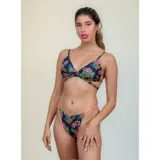 Bikini de diseño tropical con estampado de hibiscos y piñas sobre fondo negro. El top es de estilo triángulo con tiras cruzadas en el torso y la bombacha es de corte tanga con tiras laterales en color coral.